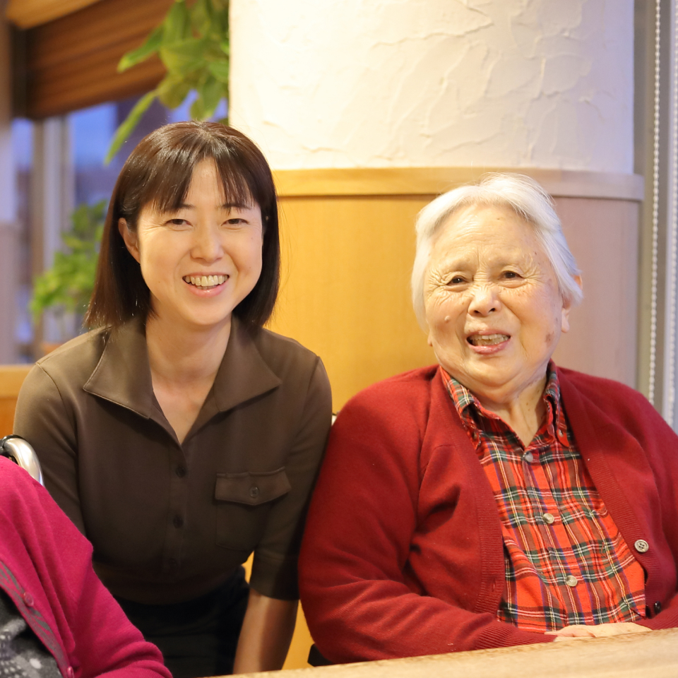 スタッフと入居者が笑顔で交流している施設内の風景